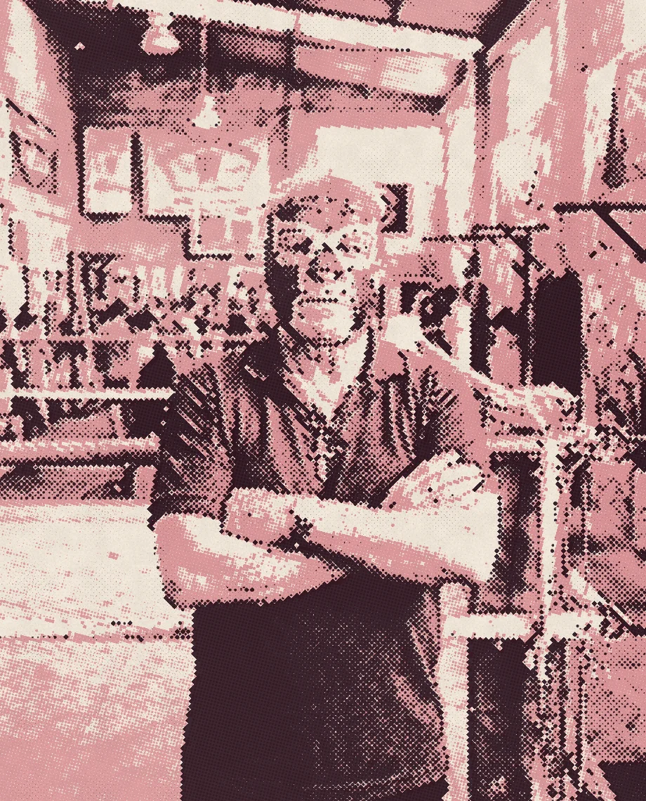 El maestro, un luchador retirado con máscara roja y azul y camisa azul, con los brazos cruzados junto a las cuerdas del ring.
